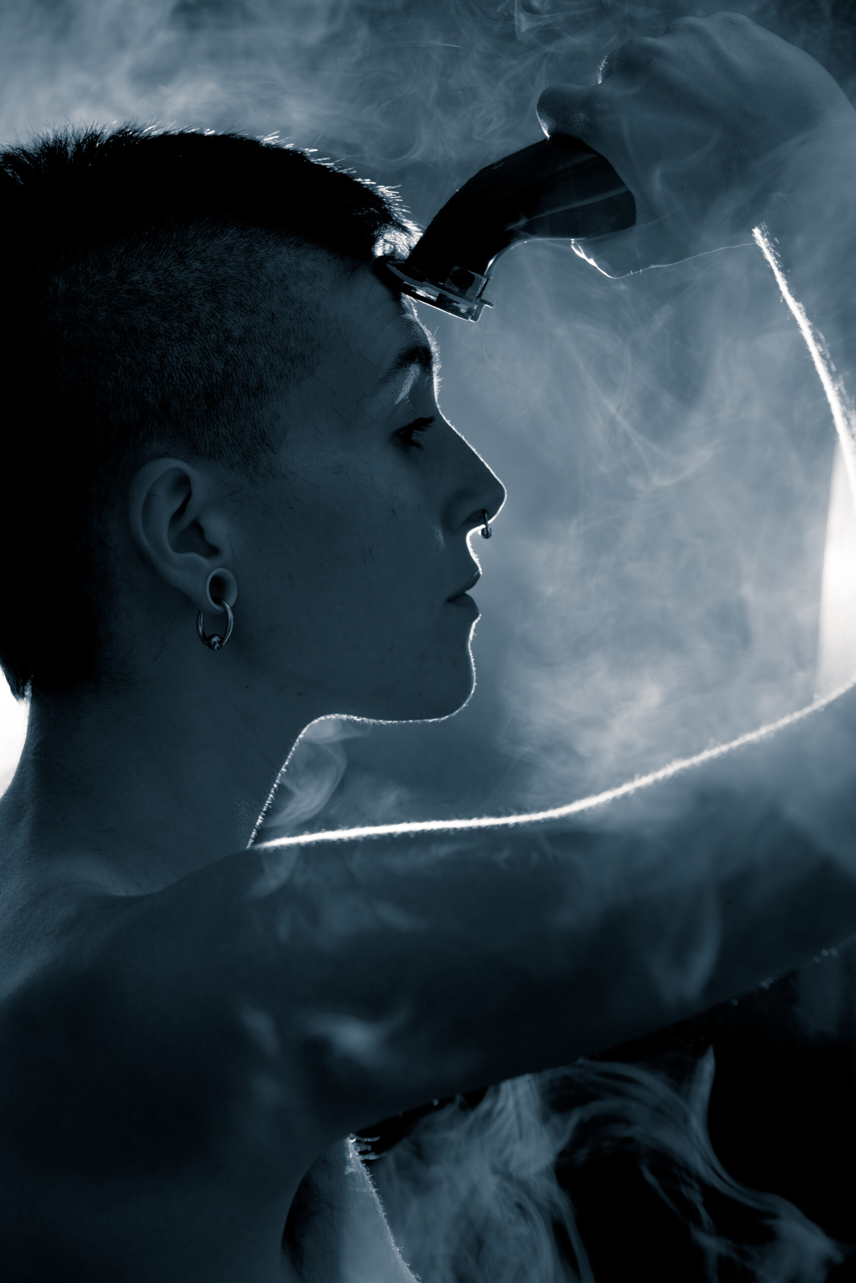 Young and attractive punk girl shaves her head in the bathroom at home. The photograph has a blue tack.